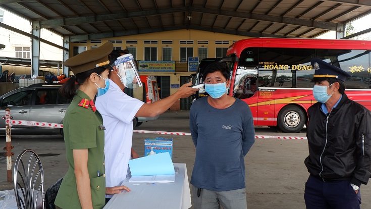 Đo thân nhiệt cho hành khách tại Bến xe Trung tâm Quy Nhơn (Ảnh: Thu Phương)