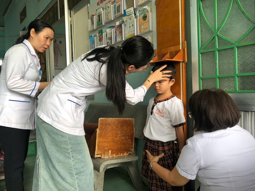 Đoàn cán bộ điều tra của Trung tâm Kiểm soát bệnh tật tỉnh cân đo trẻ tại Trạm Y tế xã Phước Thành, huyện Tuy Phước (Ảnh: Thu Phương)