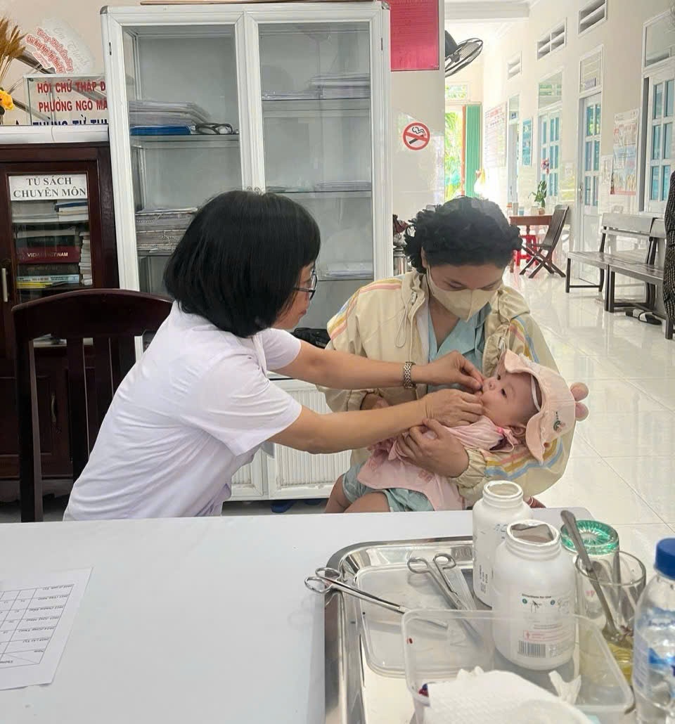 Nhân viên y tế cho trẻ uống vitamin A tại Trạm y tế phường Quy Nhơn Nam.( Ảnh Thu Hiền)